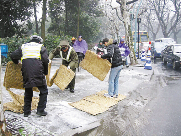 交警与市民使用防滑草支垫铺路